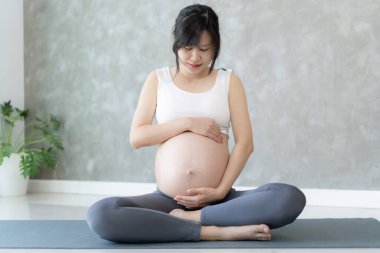 Egzersiz minderi üzerinde yoga yapan hamile kadın. Yakın dönem için meditasyon yapıyorum. Çekici, hamile kadın eğlencesi ve yoga ile rahatlamak, nefes almak ve sakin olmak. Kişisel Bakım