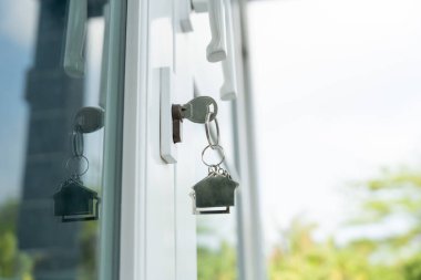 Landlord key for unlocking house is plugged into the door. Second hand house for rent and sale. keychain is blowing in the wind. mortgage for new home, buy, sell, renovate, investment, owner, estat