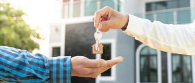 Kira, kiralama ve ev satma. Emlakçının elinde yeni sahibinin anahtarı var. kira, satış, kredi finans, sigorta, satıcı, dağıtıcı, taksit, satın alma, satma, taşınma