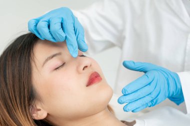 Estetik ameliyat, güzellik, cerrah ya da kadın yüzüne dokunan güzellik uzmanı burun şeklini değiştiren cerrahi prosedür, doktor burun estetiğinden önce burnunu muayene eder, tıbbi yardım, sağlık...
