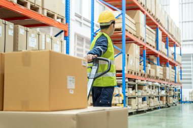 Warehouse worker pull pallet truck after inspects goods in inventory and check stock product. Transport logistic business shipping and delivery to customers.  inspection, storehouse, storage, factory
