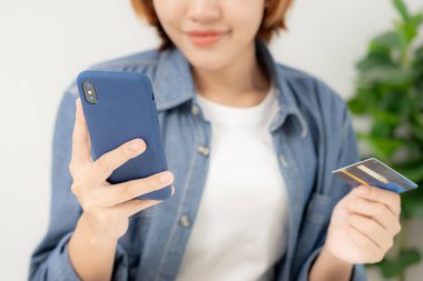 woman using smartphone for online shopping at home. Hand holding mobile phone with payment detail page display and credit card, stay home, technology, electronic commerce, internet, market place