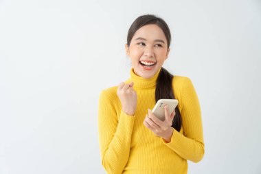 Asian beautiful woman exited surprise face expression . female feels shocked with the phone. exciting smile and happy adorable rejoices. Very enjoy and fun relax time. wow, girl holding smartphone.