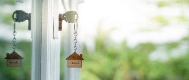 Landlord key for unlocking house is plugged into the door. Second hand house for rent and sale. keychain is blowing in the wind. mortgage for new home, buy, sell, renovate, investment, owner, estate