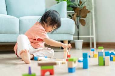 Mutlu Asyalı çocuk oyun oynuyor ve oyuncak bloklarını öğreniyor. Çocuklar evde çok mutlu ve heyecanlı. Çocuk oyun, etkinlik, gelişme ve dikkat eksikliği hiperaktivite bozukluğuyla çok iyi vakit geçiriyor