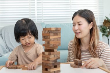 Asya Mutlu Bekar Anne küçük kızla Janga öğreniyor. Komik aile evde mutlu ve heyecanlı. Anne ve oğlu birlikte vakit geçiriyorlar. Tatil, hafta sonu, boş.