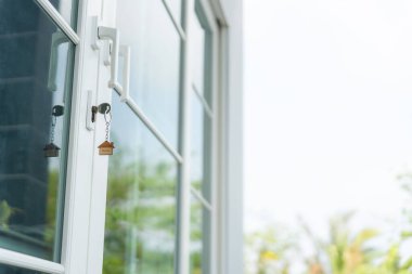 Landlord key for unlocking house is plugged into the door. Second hand house for rent and sale. keychain is blowing in the wind. mortgage for new home, buy, sell, renovate, investment, owner, estate