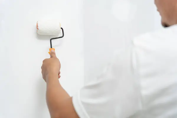 painter man, brush in hand for products to restore and paint the wall, indoor the building site of a house, wall during painting, renovation, painting, contractor, Architect, construction worker