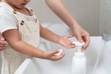 Küçük çocuk elleri sabun köpüğüyle yıkanır, temiz suyla durulanır ve mikropların eve, virüse ya da covid19 'a yayılmasını önler. Sağlık ve kişisel hijyen, virüs, bakteri