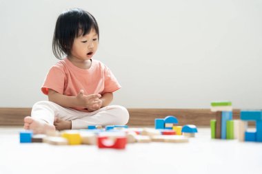 Mutlu Asyalı çocuk oyun oynuyor ve oyuncak bloklarını öğreniyor. Çocuklar evde çok mutlu ve heyecanlı. Çocuk oyun, etkinlik, gelişme ve dikkat eksikliği hiperaktivite bozukluğuyla çok iyi vakit geçiriyor