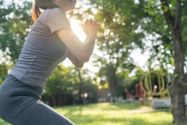 Sağlık hizmetleri görevlisi kadın parkta çalışıyor. Sabahları egzersiz yapan Asyalı bir kadın. denge, dinlenme, rahatlama, sakinlik, sağlık, mutluluk, rahatlama, sağlıklı yaşam tarzı, stresi azaltma, huzur, tutum.