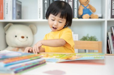 Mutlu Asyalı çocuklar evde kitap okuyarak rahatlar. Kızım ve bir hikaye okuyordum. öğrenme, çocuk bakımı, gülme, eğitim, hikaye anlatma, uygulama, hayal etme, bağımlılık cep telefonunu azaltma