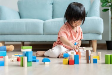 Mutlu Asyalı çocuk oyun oynuyor ve oyuncak bloklarını öğreniyor. Çocuklar evde çok mutlu ve heyecanlı. Çocuk oyun, etkinlik, gelişme ve dikkat eksikliği hiperaktivite bozukluğuyla çok iyi vakit geçiriyor