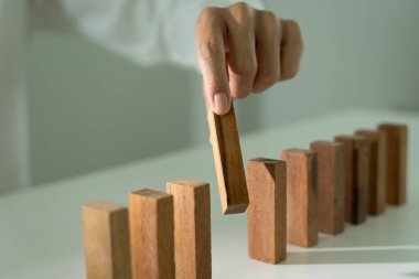 Domino 'yu elleri olan sigorta korur. İş adamı elleri iş krizinde domino taşlarının düşmesini durdurur. işletme risk denetimi ve planlama ve işletmeler sigorta işletmelerini önlemek için stratejiler.