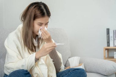 sick woman with a headache sitting under blanket, female sneezing and runny nose with seasonal influenza, allergic, high fever and influenza, resting, virus, coronavirus, feel illness, respiratory
