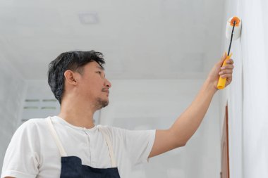 Boyacı adam, duvarları boyamak ve onarmak için el fırçası, bir evin inşaat alanı, boyama sırasında duvar, yenileme, resim, müteahhit, mimar, inşaat işçisi...