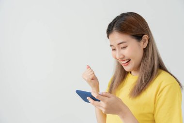 Asian beautiful woman exited surprise face expression . female feels shocked with the phone. exciting smile and happy adorable rejoices. Very enjoy and fun relax time. wow, girl holding smartphone.