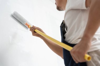 Ürünleri restore etmek ve boyamak için el ele fırça, bir evin inşaat alanı, boyama sırasında duvar, yenileme, boya, müteahhit, mimar, inşaat wo