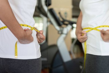 Diyet ve diyet. Güzel, ince kadın vücut ölçüsü. Spor elbiseli bir kadın sağlıklı yaşam için kilo verme hedefine, zayıflığa, ince belliye, beslenme uzmanına ulaşır..