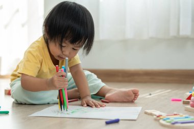 Mutlu Asya çocukları kağıt üzerinde resim yapmayı öğreniyor. Etkinlik, gelişim, IQ, EQ, meditasyon, beyin, kas, temel beceriler, ailenin birlikte zaman geçirmesi. Holida.