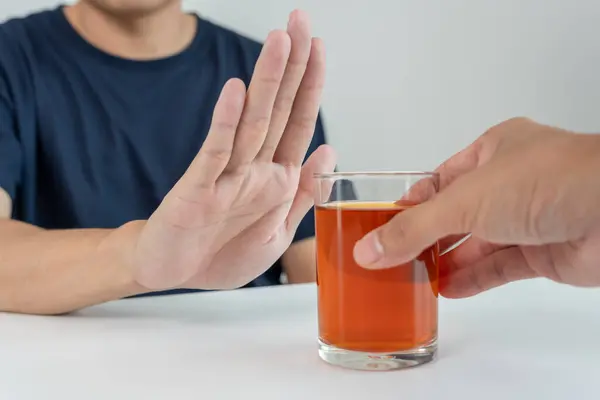 stock image man refuses say no and avoid to drink an alcohol whiskey , stopping hand sign male, alcoholism treatment, alcohol addiction, quit booze, Stop Drinking Alcohol. Refuse Glass liquor, unhealthy, reject