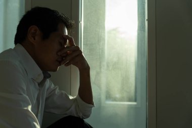 Depresyon ve akıl hastalığı. Asyalı adam kötü haber aldıktan sonra üzülür. Stresli çocuk mutsuz problemle kafasını karıştırıyor, kız arkadaşla tartışıyor, ağlıyor ve beklenmedik işler için endişeleniyor, ekonomide düşüş var..