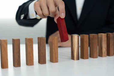 Domino 'yu elleri olan sigorta korur. İş adamı elleri iş krizinde domino taşlarının düşmesini durdurur. işletme risk denetimi ve planlama ve işletmeler sigorta işletmelerini önlemek için stratejiler.