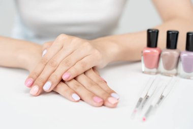 Kadın güzellik merkezinde profesyonel güzellik manikürcüsü tarafından bakım gördükten sonra güzel bir tırnak gösteriyor. Güzellik salonunda jöle tedavisi için tırnak törpüsü kullanın. Manikürcü çok güzel çivi yapıyor..