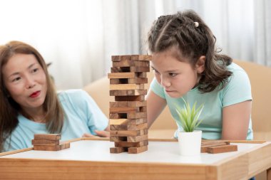 Asya 'lı mutlu anne küçük kızla Jan-ga oyunu oynuyor. Komik aile evde mutlu ve heyecanlı. Anne ve oğlu birlikte vakit geçiriyorlar. Tatil, hafta sonu, boş.