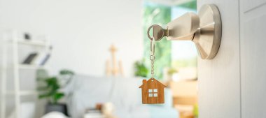 Moving house, relocation. The key was inserted into the door of the new house, inside the room was a cardboard box containing personal belongings and furniture. move in the apartment or condominium