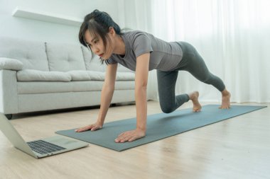 Evde ya da apartmanda yoga yapan zayıf bir kadın. Sabahları egzersiz yapan Asyalı bir kadın. denge, meditasyon, rahatlama, sakinlik, sağlık, mutluluk, rahatlama, sağlıklı yaşam tarzı, diyet, sli