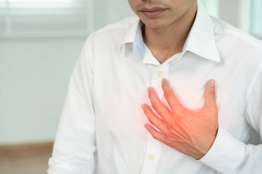 Göğüs kafesinde kalp krizi belirtileri var. Asyalı bir adamın göğüs ağrısı var. Kalp rahatsızlığı, sızıntı, genişleme, kalp büyümesi, göğsüne acı veren bir ifadeyle bastırma.