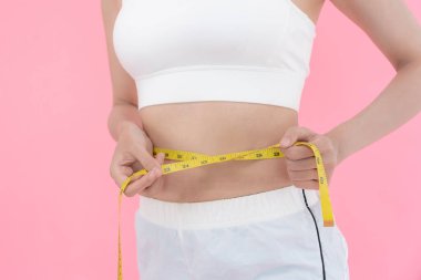 Diyet ve diyet. Güzel, ince kadın vücut ölçüsü. Spor elbiseli bir kadın sağlıklı yaşam için kilo verme hedefine, zayıflığa, ince belliye, beslenme uzmanına ulaşır..