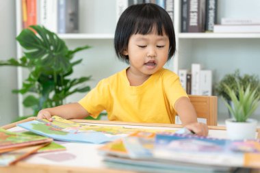 Mutlu Asyalı çocuklar evde kitap okuyarak rahatlar. Kızım ve bir hikaye okuyordum. öğrenme, çocuk bakımı, gülme, eğitim, hikaye anlatma, uygulama, hayal etme, bağımlılık cep telefonunu azaltma