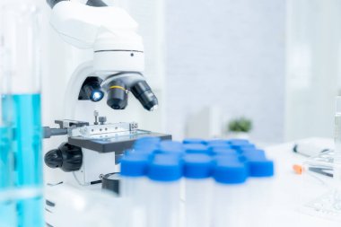 Gelişmiş bilim laboratuarındaki biyokimyasal örnekleri analiz et. Tıbbi profesyonel kullanım mikroskobu virüsün mikrobiyolojik gelişimini gösteriyor. Fen laboratuvarında biyoteknoloji araştırması.