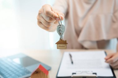 Kira, kiralama ve ev satma. Emlakçının elinde yeni sahibinin anahtarı var. kira, satış, kredi finans, sigorta, satıcı, dağıtıcı, taksit, satın alma, satma, taşınma