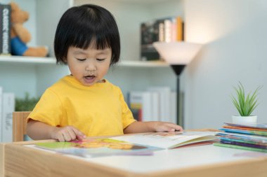 Mutlu Asyalı çocuklar evde kitap okuyarak rahatlar. Kızım ve bir hikaye okuyordum. öğrenme, çocuk bakımı, gülme, eğitim, hikaye anlatma, uygulama, hayal etme, bağımlılık cep telefonunu azaltma