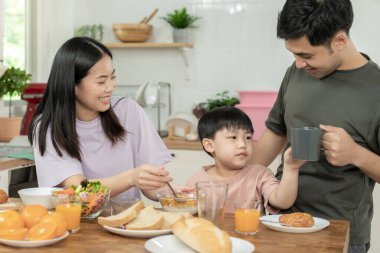 Aile zamanı, kahvaltı, tatillerde birlikte aktiviteler. Ebeveynler ve çocuklar tatillerde birlikte yemek yiyorlar. Sabah aile için yeni bir ev, iyi eğlenceler, hafta sonu, boş zaman