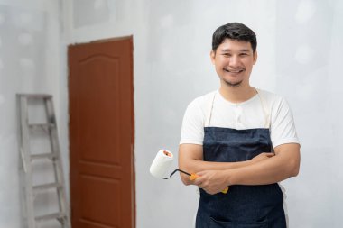 Boyacı adam, duvarları boyamak ve onarmak için el fırçası, bir evin inşaat alanı, boyama sırasında duvar, yenileme, resim, müteahhit, mimar, inşaat işçisi...