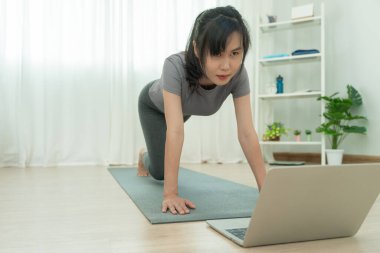 Evde ya da apartmanda yoga yapan zayıf bir kadın. Sabahları egzersiz yapan Asyalı bir kadın. denge, meditasyon, rahatlama, sakinlik, sağlık, mutluluk, rahatlama, sağlıklı yaşam tarzı, diyet, ince
