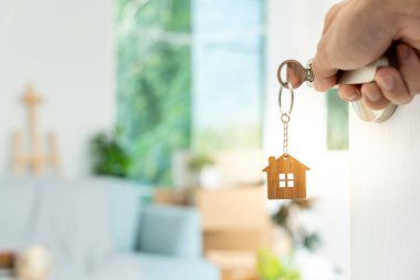 Moving house, relocation. The key was inserted into the door of the new house, inside the room was a cardboard box containing personal belongings and furniture. move in the apartment or condominium