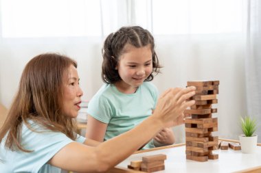 Asya 'lı mutlu anne küçük kızla Jan-ga oyunu oynuyor. Komik aile evde mutlu ve heyecanlı. Anne ve oğlu birlikte vakit geçiriyorlar. Tatil, hafta sonu, boş