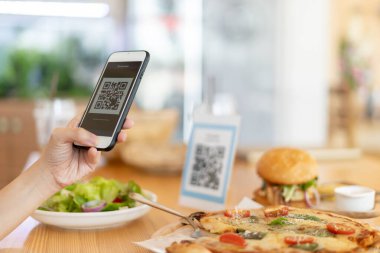 Woman use smartphone to scan QR code to pay in cafe restaurant with a digital payment without cash. Choose menu and order accumulate discount. E wallet, technology, pay online, credit card, bank app.