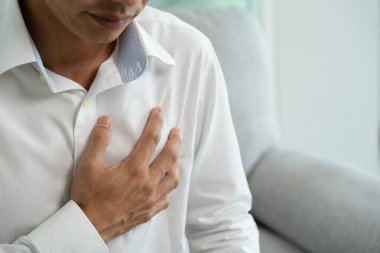 Göğüs kafesinde kalp krizi belirtileri var. Asyalı bir adamın göğüs ağrısı var. Kalp rahatsızlığı, sızıntı, genişleme, kalp büyümesi, göğsüne acı veren bir ifadeyle bastırma.
