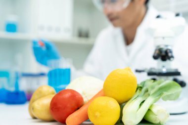 Bilimadamı laboratuvardaki kimyasal gıda kalıntılarını kontrol ediyor. Denetim uzmanları sebzelerin kalitesini inceler. Laboratuvar, tehlikeli maddeler, yasaklı maddeler, kirlilik, mikroskop, mikrobiyolog