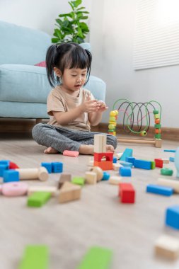 Mutlu Asyalı çocuk oyun oynuyor ve oyuncak bloklarını öğreniyor. Çocuklar evde çok mutlu ve heyecanlı. Çocuk oyun, etkinlik, gelişme ve dikkat eksikliği hiperaktivite bozukluğuyla çok iyi vakit geçiriyor