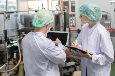 Kalite denetleyicisi, yiyecek veya içecek teknisyeni, müşteriye ürün göndermeden önce durum kontrolü gıda ve içeceklerle ilgili teftiş yapıyor. Üretim lideri makine ve verimliliği yeniden kontrol ediyor.