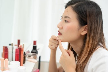 Genç Asyalı kadın, yüz dermatolojisi ve kozmetik ürünlerinde steroidlere alerjisi olduğu için endişeli. Hassas cilt, güneş yanığı, sivilce, kimyasallara alerjisi, yüzünde kızarıklık. cilt sorunları ve güzellik