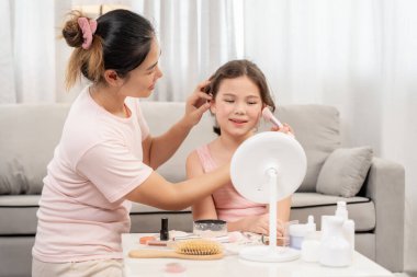 Anne mutlu çocuklar için makyaj yapıyor ve öğretmenlik yapıyor. Makyaj yapan kız. Aktivite ailesi, Reklam, yaşam tarzı, kozmetik, makyaj malzemeleri, güzellik etkinliği, güzellik uzmanı, yetenek, aşk güzeli.
