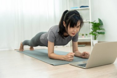 Evde ya da apartmanda yoga yapan zayıf bir kadın. Sabahları egzersiz yapan Asyalı bir kadın. denge, meditasyon, rahatlama, sakinlik, sağlık, mutluluk, rahatlama, sağlıklı yaşam tarzı, diyet, ince